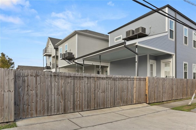 view of side of property with cooling unit and fence