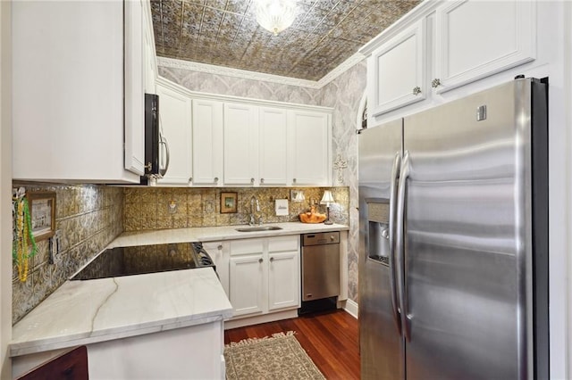 kitchen featuring appliances with stainless steel finishes, ornamental molding, sink, white cabinets, and dark hardwood / wood-style floors