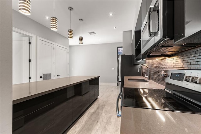 kitchen with decorative light fixtures, sink, decorative backsplash, and stainless steel appliances