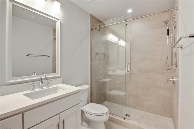 bathroom with vanity, toilet, and a shower with shower door