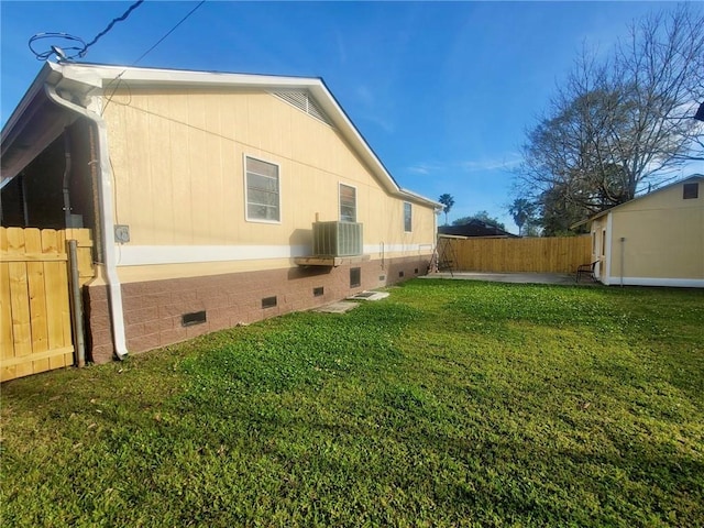 view of side of home featuring a yard, cooling unit, and a patio