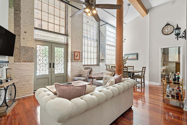 living room with a towering ceiling, french doors, dark hardwood / wood-style floors, and ceiling fan