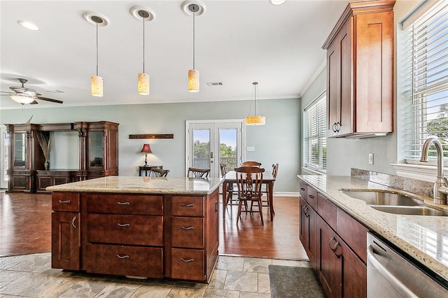 kitchen with plenty of natural light, stainless steel dishwasher, decorative light fixtures, and sink