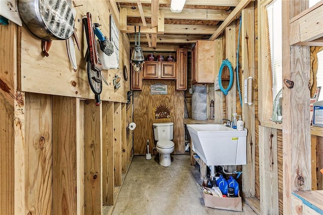 bathroom with sink, concrete flooring, and toilet