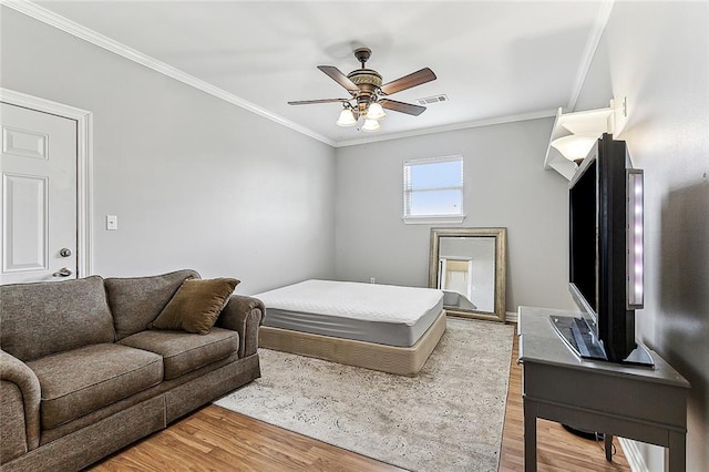 bedroom with ceiling fan, wood-type flooring, and ornamental molding