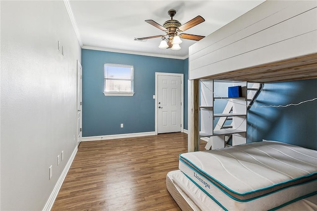 bedroom featuring dark hardwood / wood-style floors, ceiling fan, and crown molding