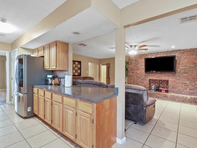 kitchen featuring light tile patterned floors, brick wall, and a textured ceiling