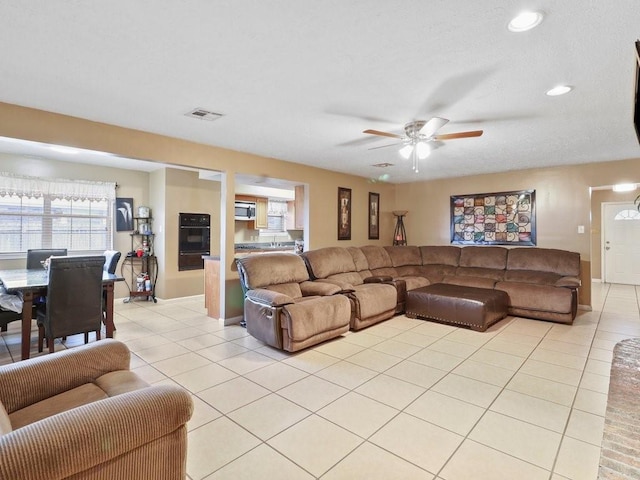 living room featuring ceiling fan and light tile patterned flooring