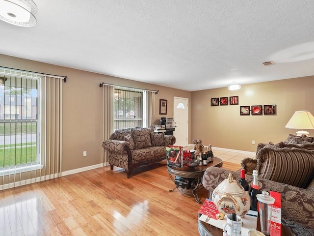 living room with a wealth of natural light, a textured ceiling, and hardwood / wood-style flooring