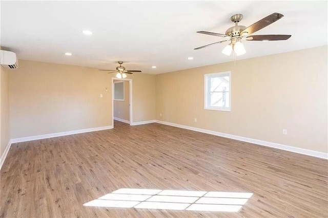 spare room with light hardwood / wood-style floors, a wall mounted AC, and ceiling fan