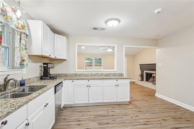 kitchen featuring white cabinetry, a fireplace, and light wood-type flooring