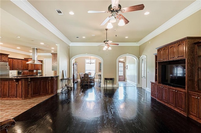 living room with ceiling fan with notable chandelier, hardwood / wood-style flooring, and crown molding