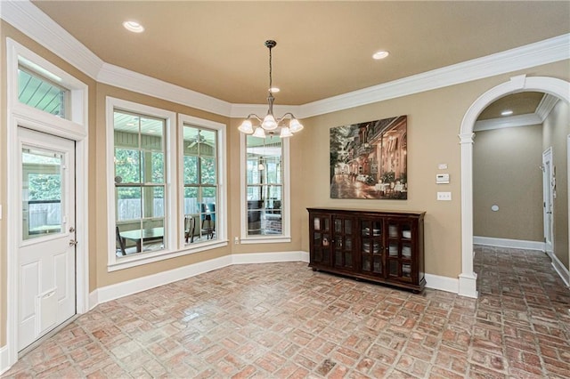 unfurnished dining area featuring crown molding and a chandelier