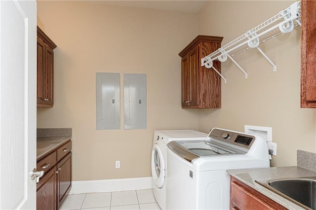 laundry room with washer and dryer, light tile patterned flooring, cabinets, and electric panel