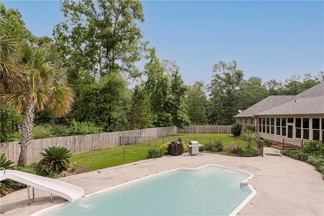 view of pool featuring a yard, a patio area, and a water slide