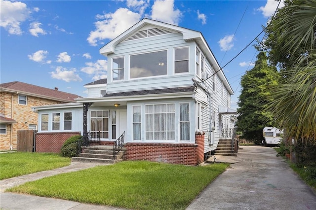 view of front facade with brick siding and a front yard