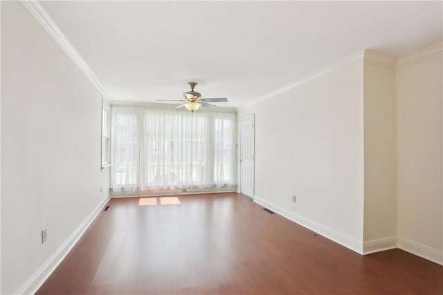 empty room with baseboards, ornamental molding, and dark wood-style flooring