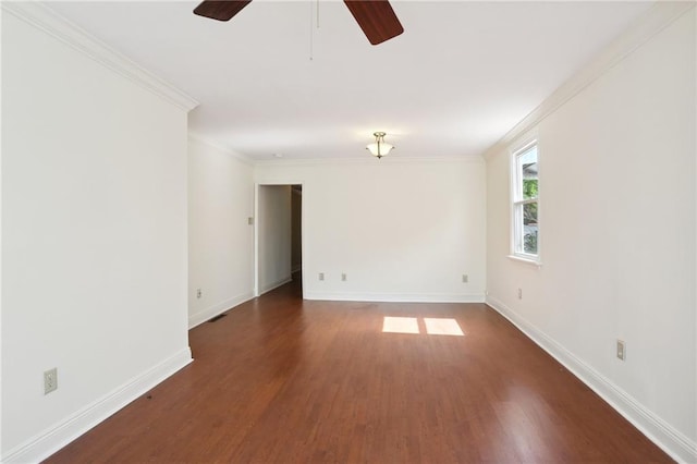 unfurnished room with dark wood-style floors, ornamental molding, and baseboards