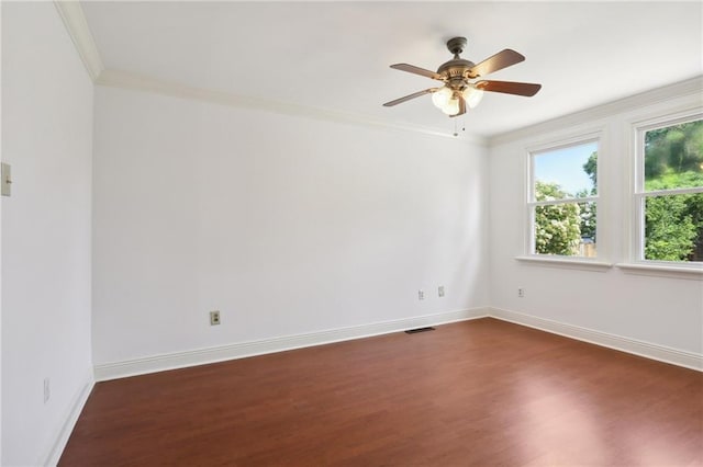 unfurnished room with dark wood-style floors, baseboards, visible vents, and crown molding