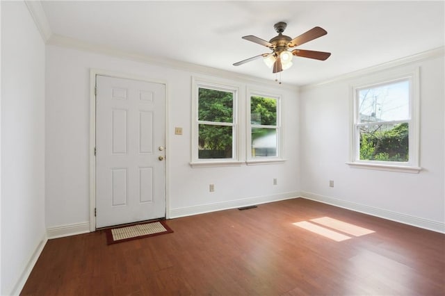 entryway with crown molding, dark wood finished floors, visible vents, a ceiling fan, and baseboards