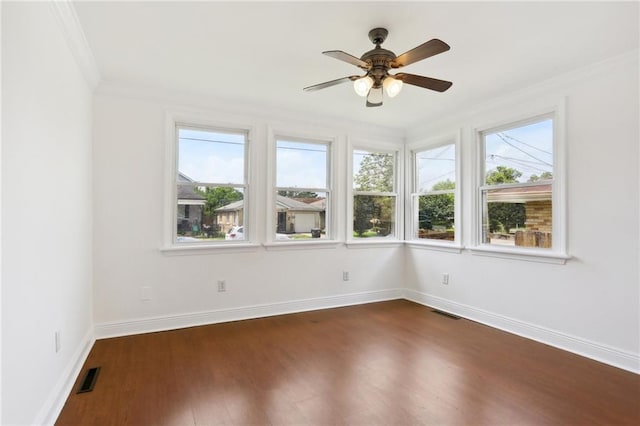 unfurnished sunroom featuring a ceiling fan, a wealth of natural light, and visible vents