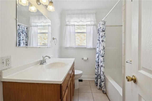 bathroom with toilet, a wealth of natural light, tile patterned flooring, and vanity