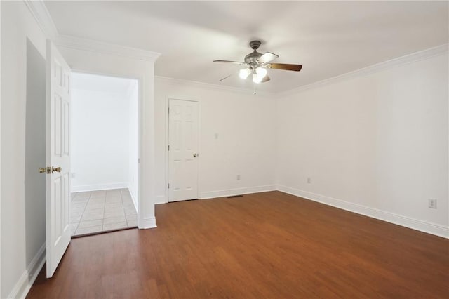 spare room featuring ornamental molding, ceiling fan, baseboards, and wood finished floors