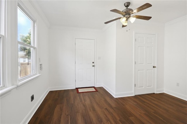 unfurnished room with crown molding, baseboards, and dark wood-style flooring