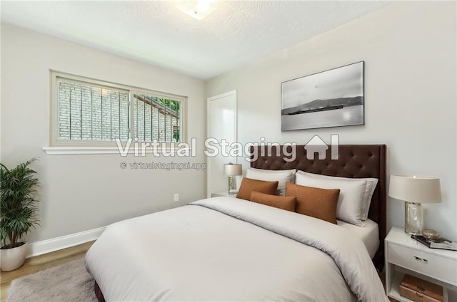 bedroom with hardwood / wood-style floors and a textured ceiling