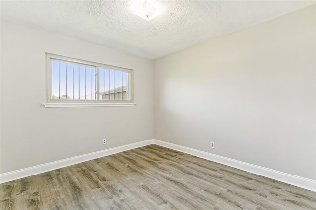 unfurnished room featuring wood-type flooring and a textured ceiling