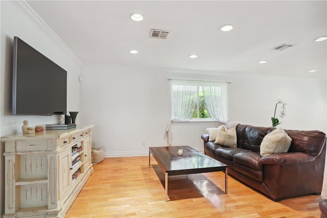 living room with light hardwood / wood-style flooring and crown molding