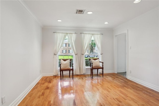 sitting room featuring ornamental molding and hardwood / wood-style flooring