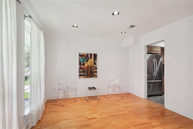 spare room featuring light wood-type flooring and ornamental molding