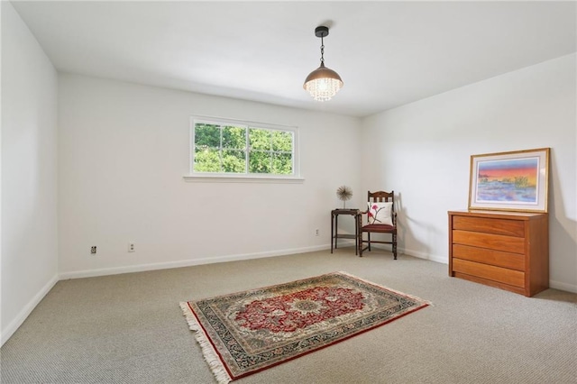 sitting room featuring carpet flooring and a chandelier