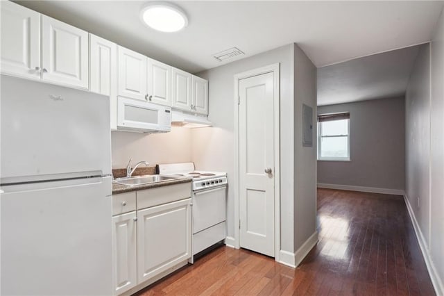 kitchen featuring wood-type flooring, white cabinets, sink, and white appliances