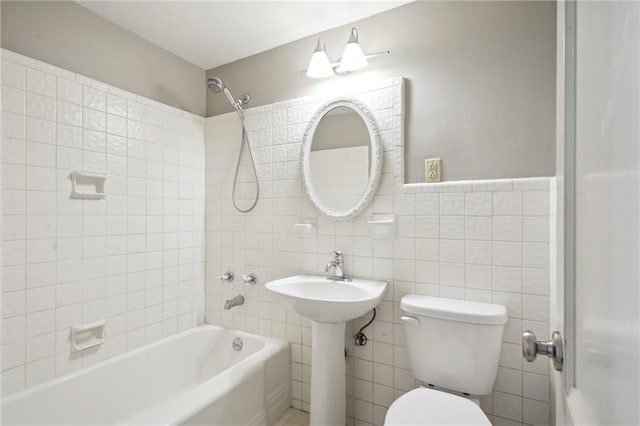 bathroom with tile walls, tasteful backsplash, tiled shower / bath, and toilet