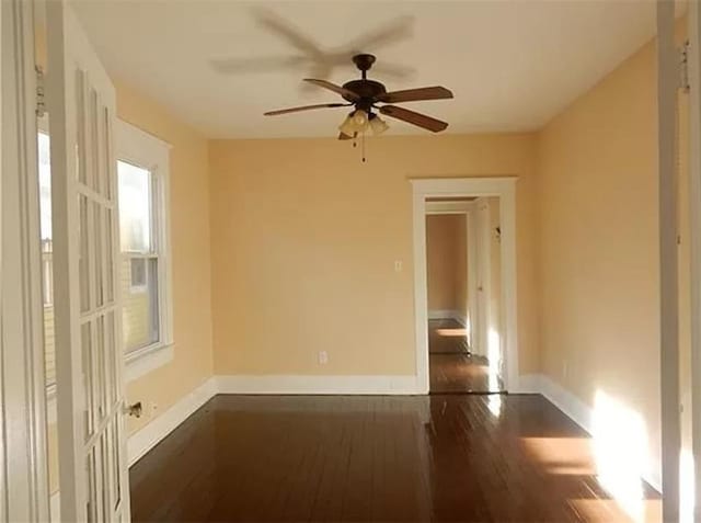 empty room with dark wood-type flooring and ceiling fan