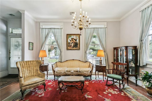 living area featuring an inviting chandelier, hardwood / wood-style flooring, and crown molding