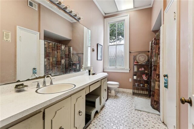 bathroom with vanity, toilet, tile patterned floors, and ornamental molding