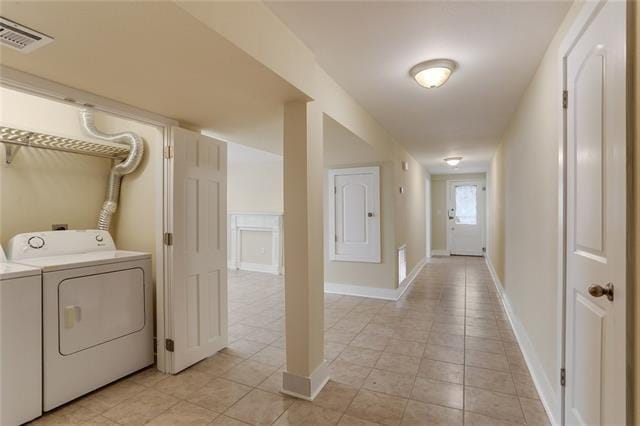 laundry area with light tile patterned floors and washer and clothes dryer