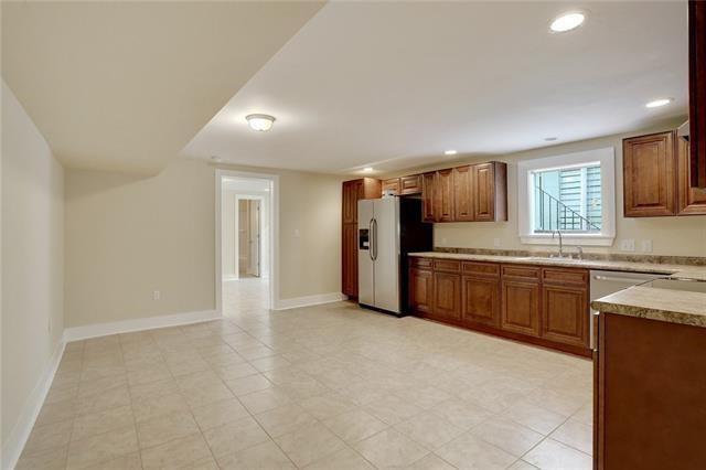 kitchen featuring stainless steel fridge with ice dispenser, sink, and light tile patterned floors