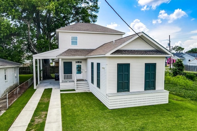 rear view of property with a lawn, a porch, and a carport