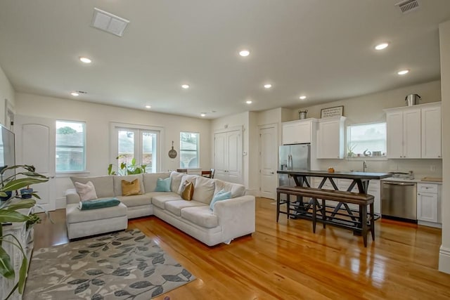 living area featuring recessed lighting, visible vents, and light wood-style flooring