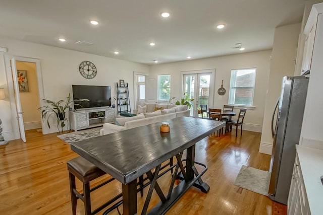 kitchen featuring baseboards, recessed lighting, freestanding refrigerator, white cabinetry, and light wood-type flooring