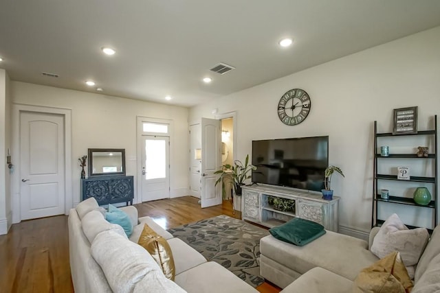 living room with visible vents, recessed lighting, and wood finished floors