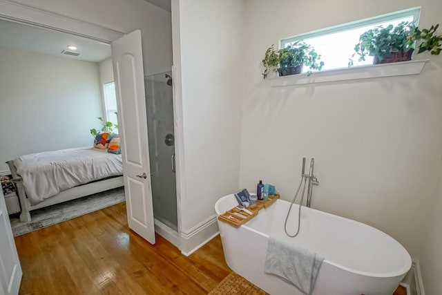 full bathroom featuring visible vents, a freestanding bath, a stall shower, ensuite bathroom, and wood finished floors