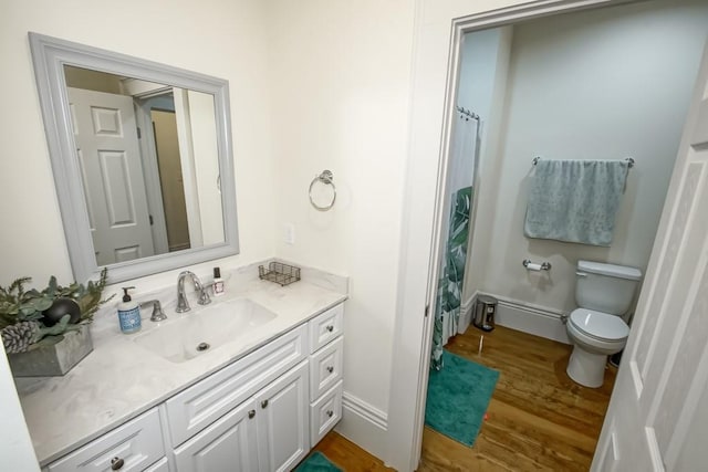 full bathroom with vanity, wood finished floors, baseboards, curtained shower, and toilet