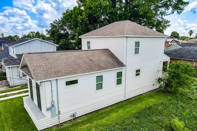 view of property exterior featuring a yard and a shingled roof