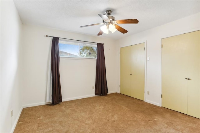 unfurnished bedroom featuring ceiling fan and light carpet