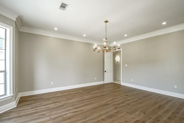 spare room with dark hardwood / wood-style floors, ornamental molding, and an inviting chandelier